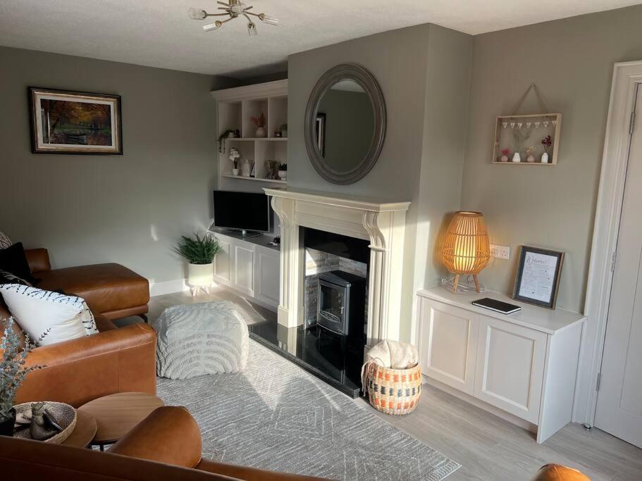 uma sala de estar com lareira e espelho em Sarah’s cottage em Newry
