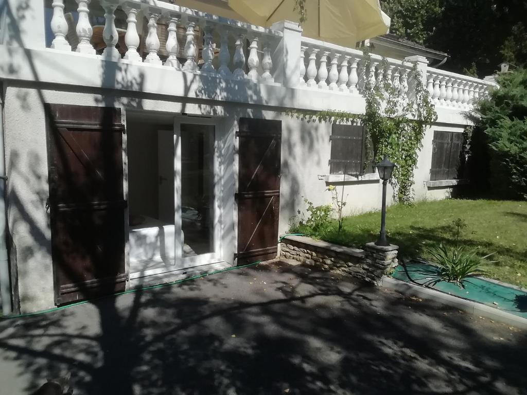a white house with a gate and a fence at Logement avec 2 chambres pour 5 personnes maxi 