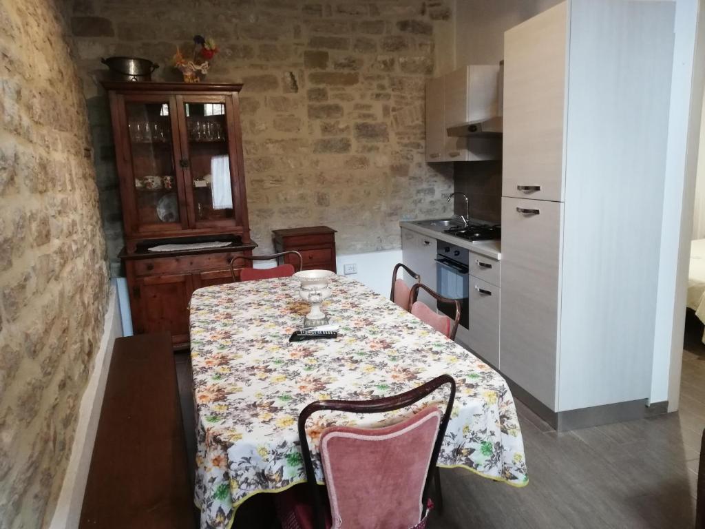 cocina con mesa con sillas y mantel en A Casa Grelletto Gubbio, en Gubbio