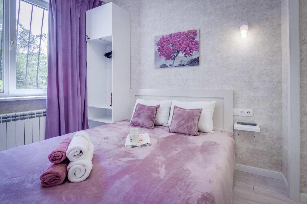 - une chambre avec un grand lit et des serviettes dans l'établissement Asaapart Orbita 2, à Almaty