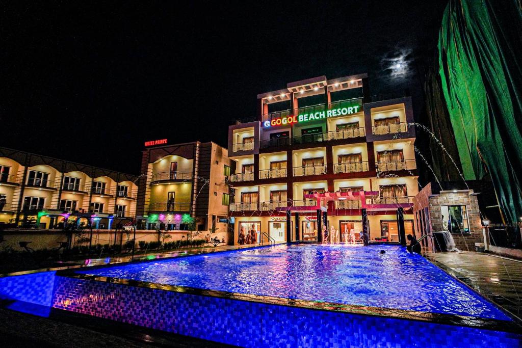 a large pool of blue lights in front of a building at Gogol Beach Resort in Mandarmoni
