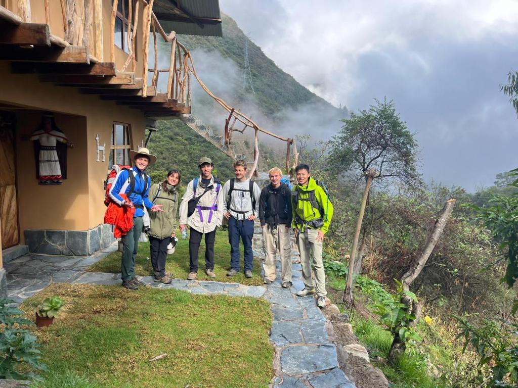 a group of people standing in front of a mountain at Salkantay Hostel Chaullay in Santa Teresa