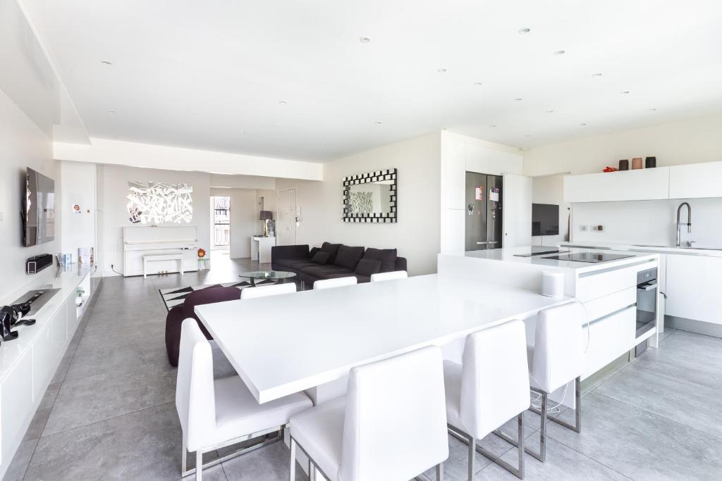 Il comprend une cuisine blanche et un salon avec une grande table blanche. dans l'établissement Luxury Eiffel Tower Paris, à Paris