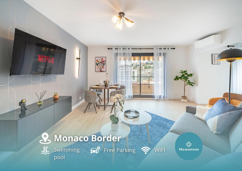 ein Wohnzimmer mit einem blauen Sofa und einem TV in der Unterkunft Monaco Border, sea view, Parking in Beausoleil