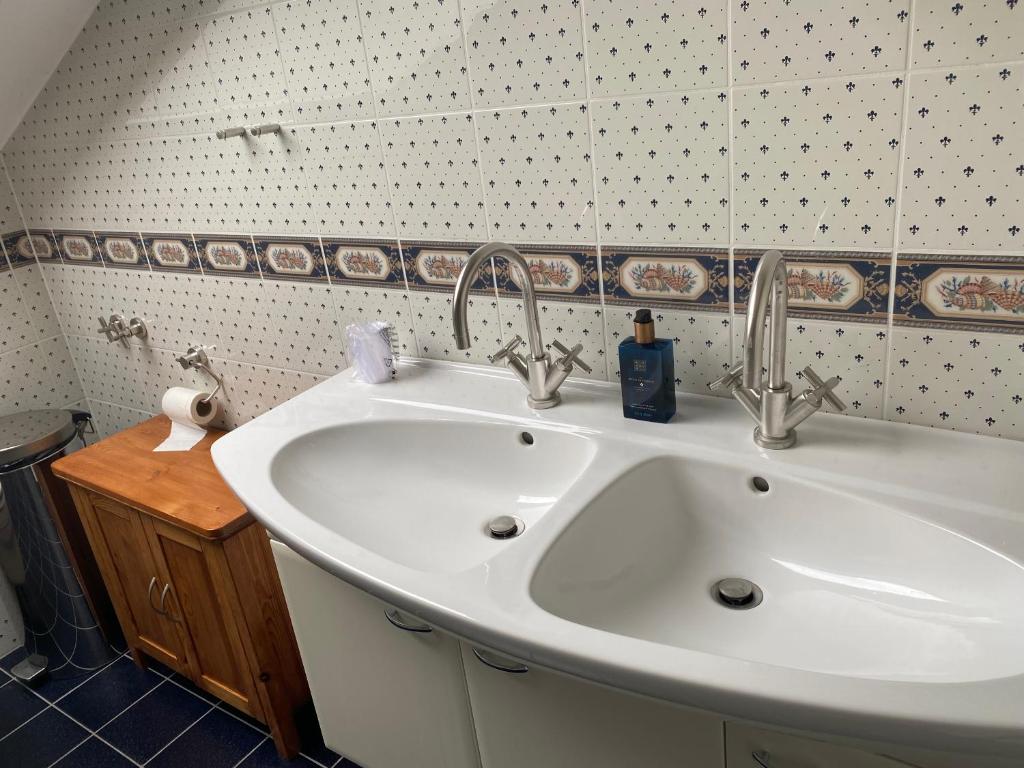 um lavatório de casa de banho com duas torneiras em cima em Gemütliches Zimmer mit großem Bad em Recklinghausen