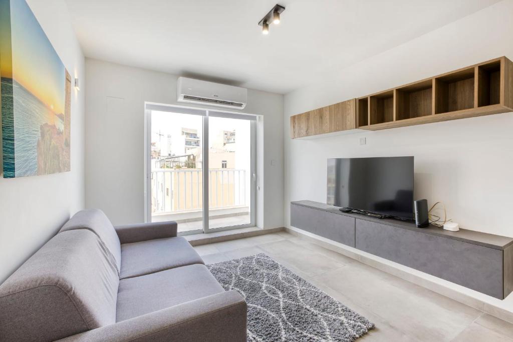 a living room with a couch and a tv at GZIRA Suite 14-Hosted by Sweetstay in Il-Gżira