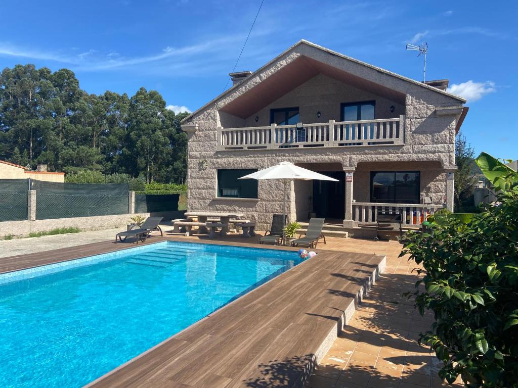 a villa with a swimming pool and a house at A CASA DE SISAN in Ribadumia