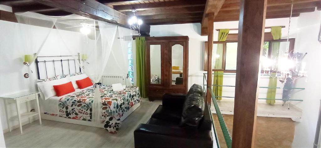 een kleine slaapkamer met een bed en een bank bij Dúplex Ca tío Celso in San Esteban de la Sierra