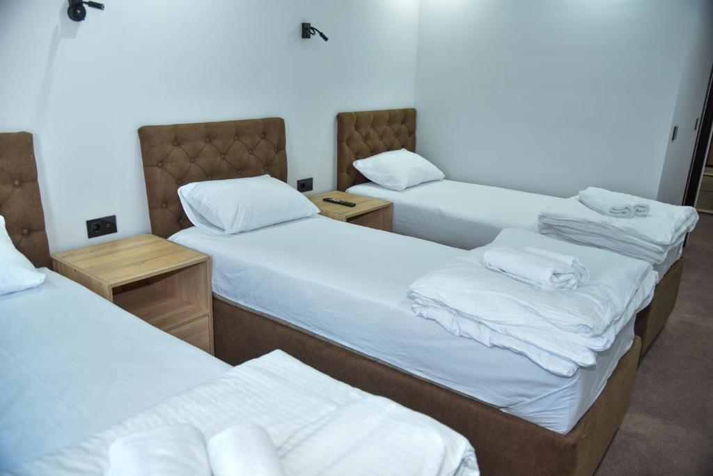 a group of three beds in a room at Apartmani COLOSSEUM in Bratunac