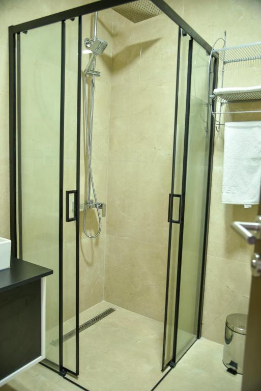 a shower with a glass door in a bathroom at Apartmani COLOSSEUM in Bratunac