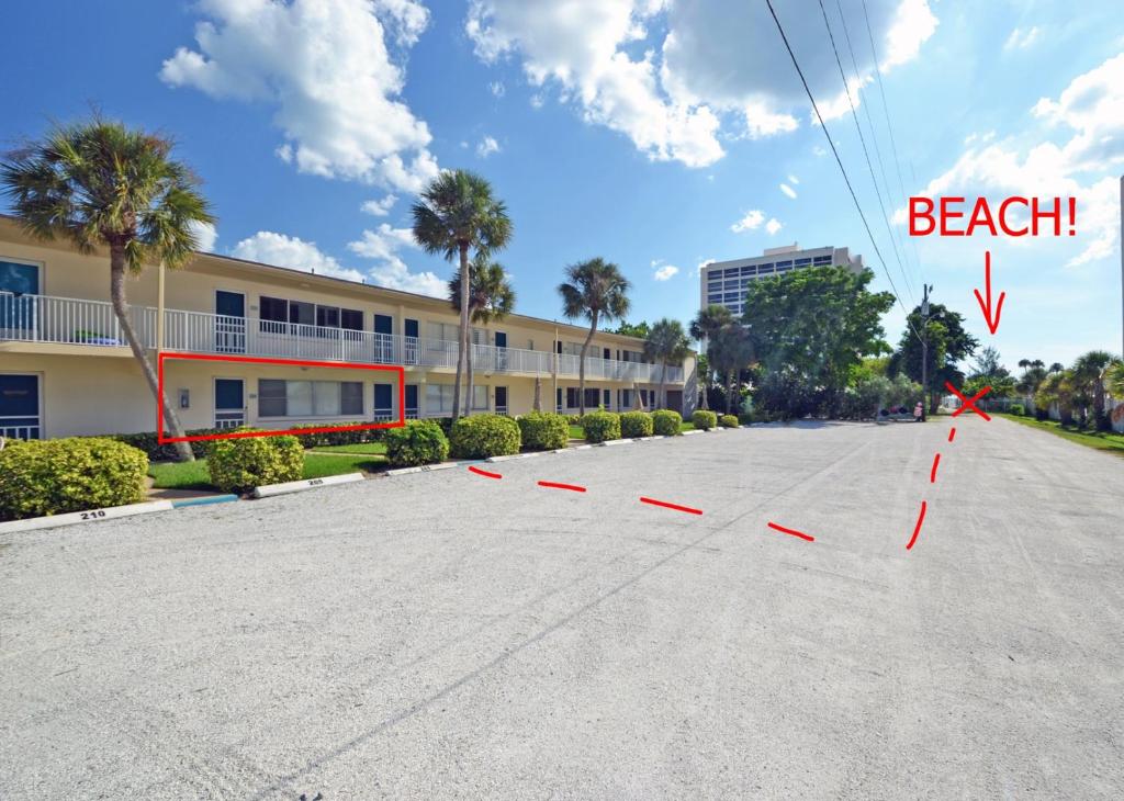 an empty parking lot in front of a building at Siesta Beach Condo Rental with direct beach and pool access in Siesta Key