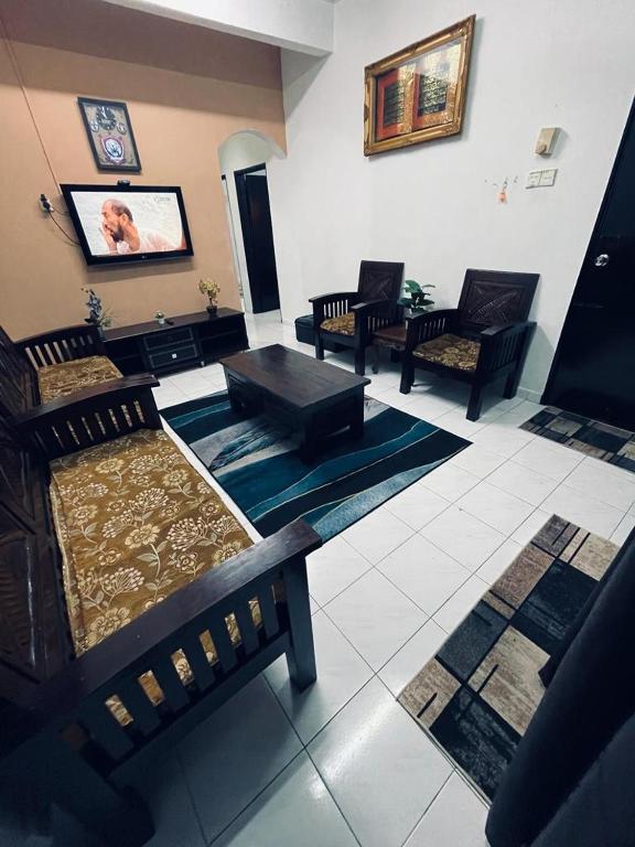 a living room with several chairs and a table at Daliya Homestay Ulu Tiram JB in Ulu Tiram