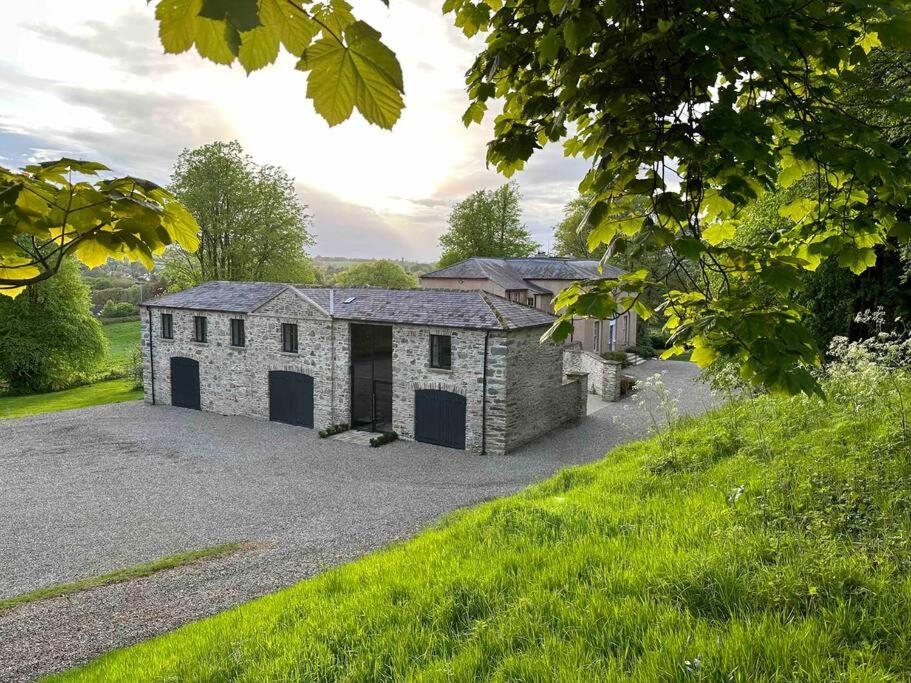 a stone house with a garage on a gravel driveway at The Hayloft in Strabane