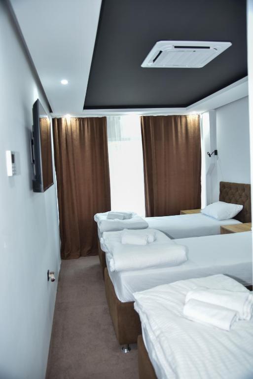 a row of beds in a room with a tv at Apartmani COLOSSEUM in Bratunac