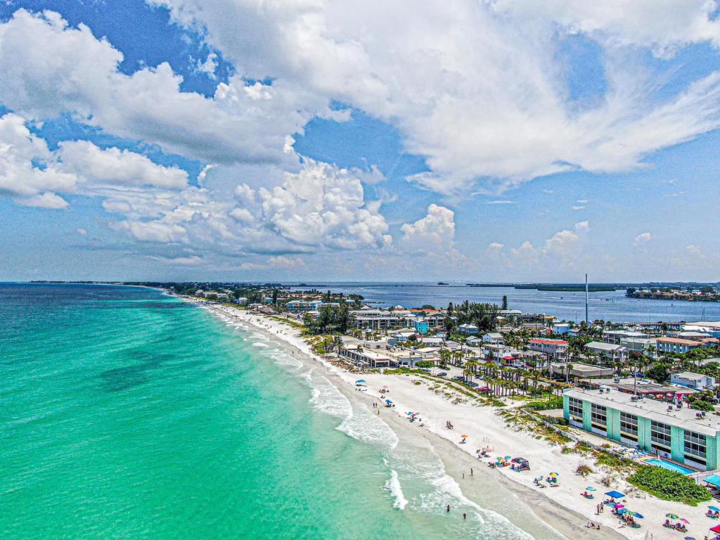 an aerial view of a beach with people and the ocean at Two story condo with ocean on one side and bay on other only steps away in Bradenton Beach