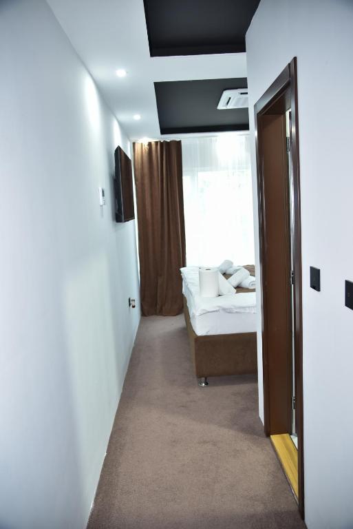 a room with a bed and a door to a bedroom at Apartmani COLOSSEUM in Bratunac