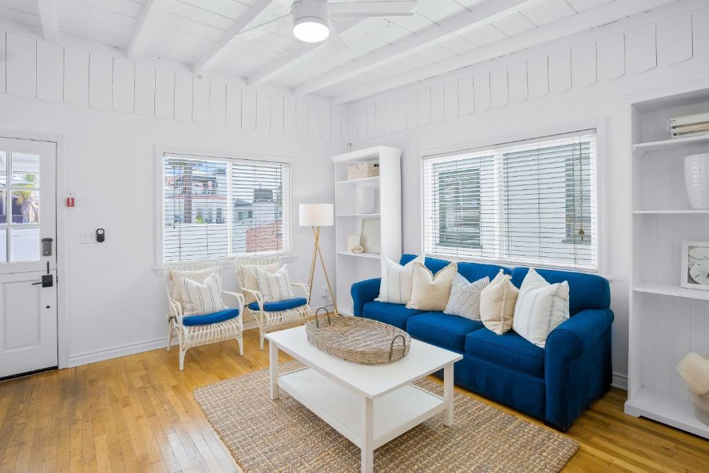 a living room with a blue couch and a table at Newport Beach Cottage B in Newport Beach