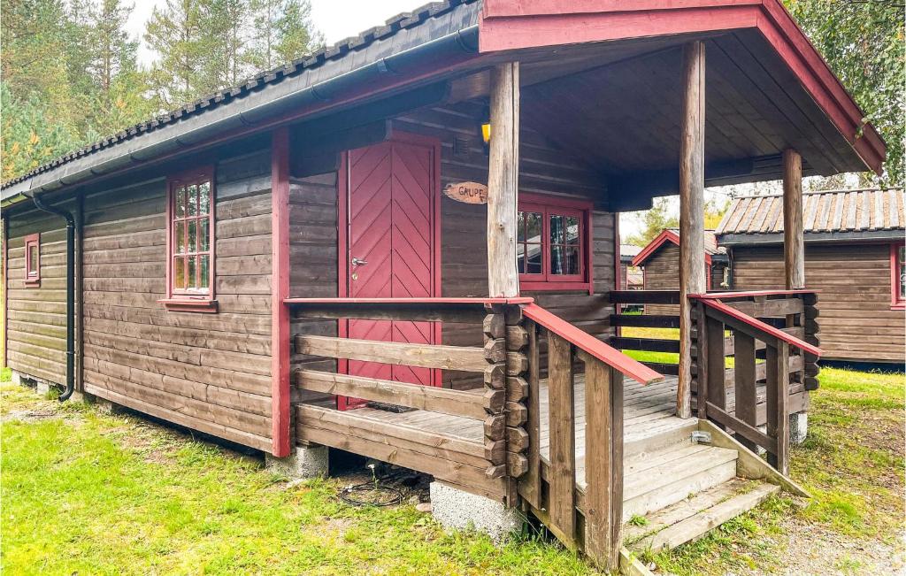 uma cabina de madeira com uma porta vermelha num campo em Beautiful Home In Grue Finnskog With Kitchen em Svullrya