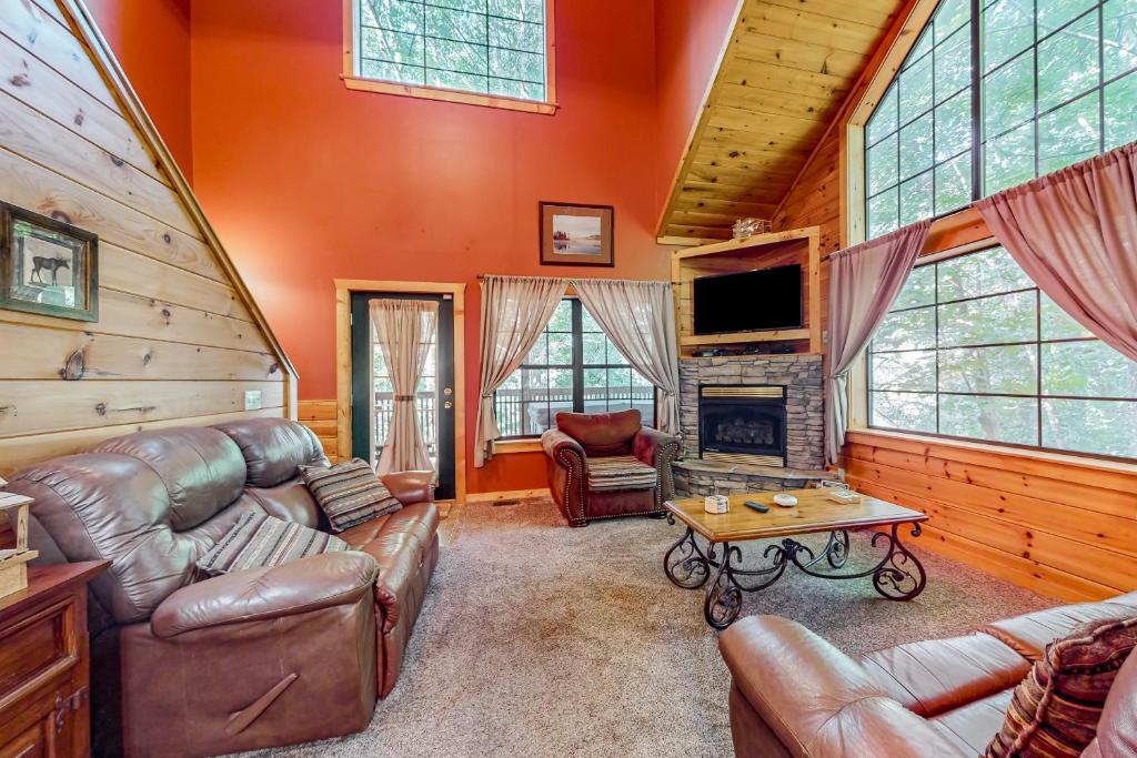 a living room with leather furniture and a fireplace at Cozy Cub Cabin in Gatlinburg
