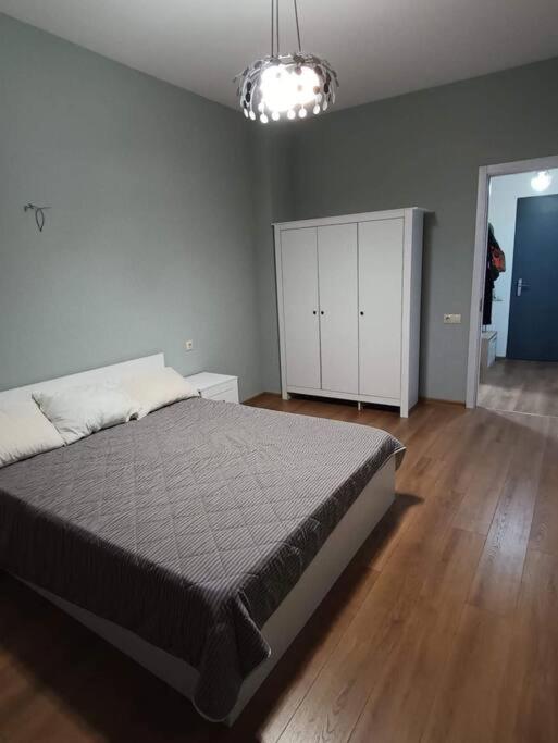 een slaapkamer met een bed en een witte kast bij Apartment in Politovskaia st in Agaraki