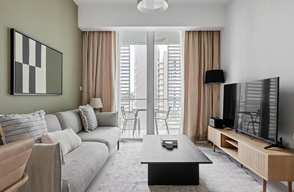Spectacular 2BR Apartment in Singapore في سنغافورة: غرفة معيشة مع أريكة وتلفزيون