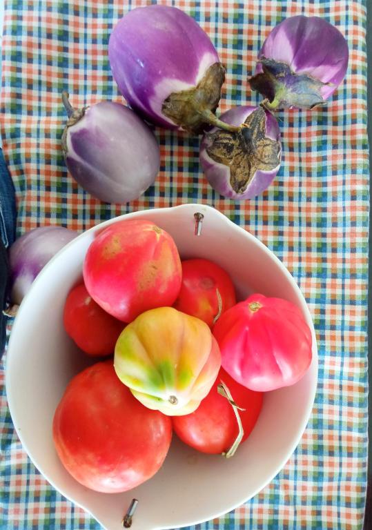a bowl of tomatoes and onions on a table at Message in a Bottle Bed and Breakfast in Camporosso