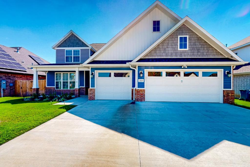 a house with two garage doors on a driveway at Life is Good on 18th Street in Bentonville