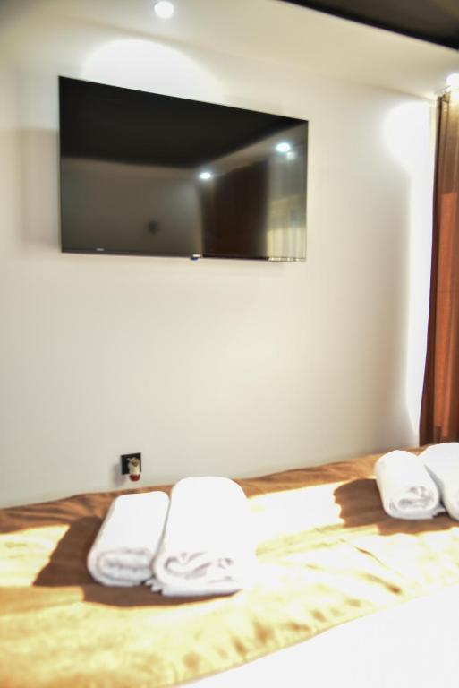 a bedroom with a bed with a tv on the wall at Apartmani COLOSSEUM in Bratunac