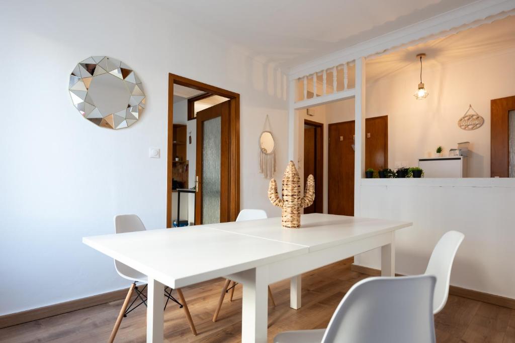 - une salle à manger blanche avec une table et des chaises blanches dans l'établissement Appartement cosy de 80 m2, à Mulhouse