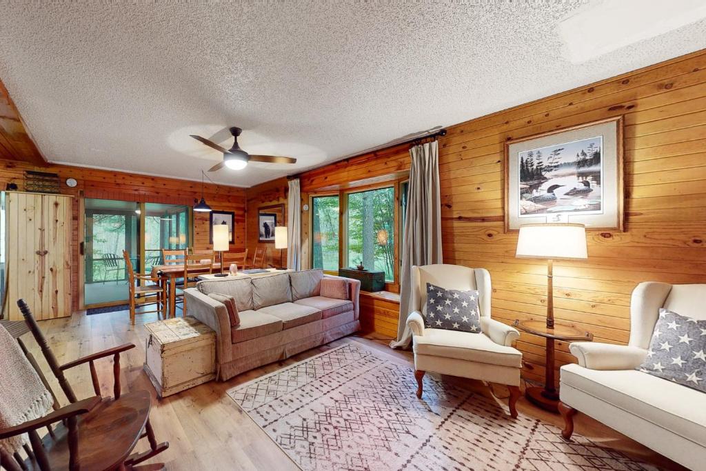een woonkamer met een bank, stoelen en een tafel bij Northwoods Resort in Woodruff