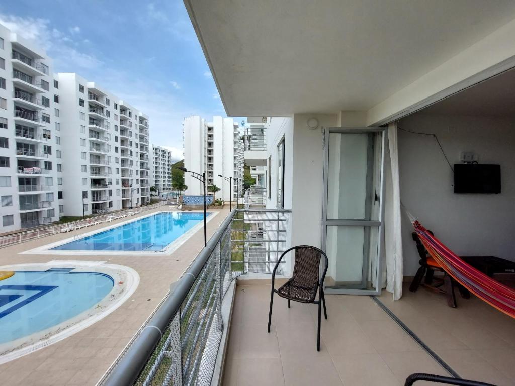 a balcony with a view of a swimming pool on a building at Aqualina Orange Hermoso Apartamento Piso 3 Vista a Piscina in Girardot