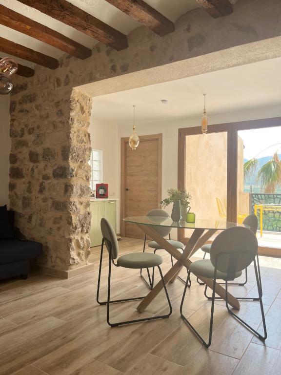 a dining room with a table and chairs at El Brollador in Corbera