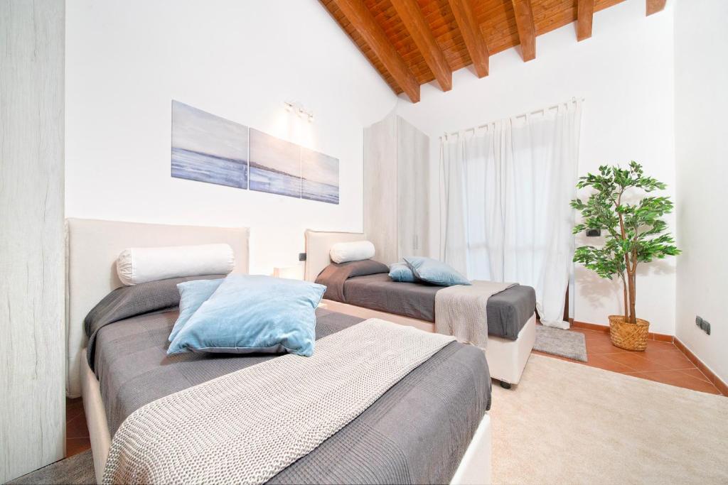 a bedroom with two beds and a tree in it at Terre dei Consoli Resort e Golf in Monterosi