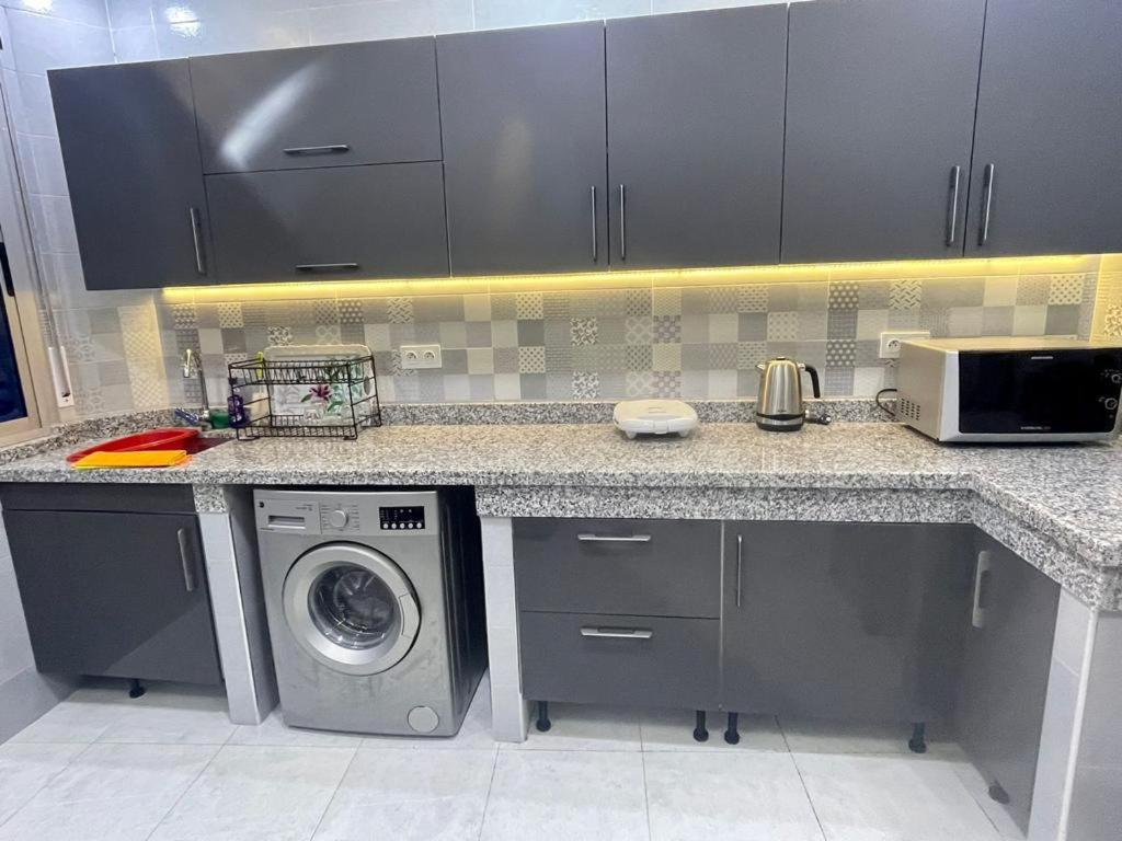 a kitchen with a washing machine under a counter at IDEAL in Tangier