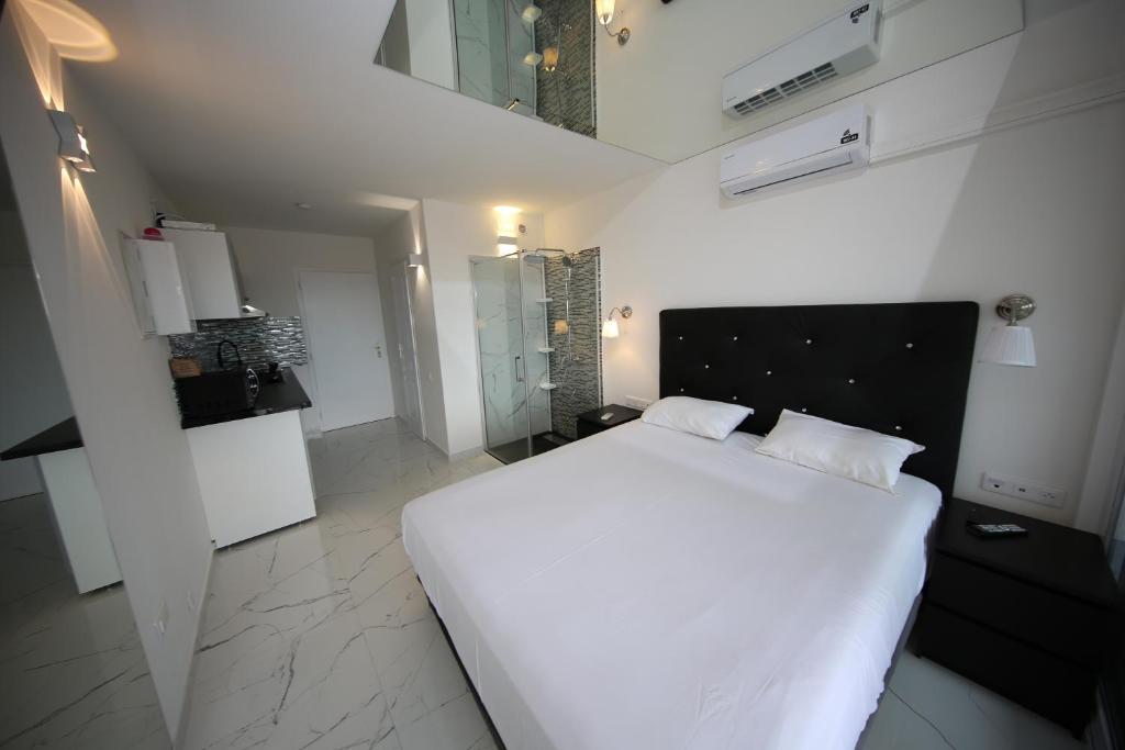 1 dormitorio con 1 cama blanca grande en una habitación en Studio Indecent, en Cap d'Agde