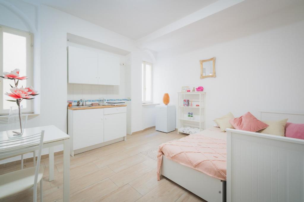 a bedroom with a bed and a table and a kitchen at Suite "Castello" del Garda - APT per coppie Garda in Desenzano del Garda