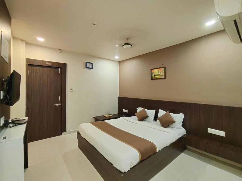 a bedroom with a bed and a television in it at Hotel Palav Palace in Ahmedabad