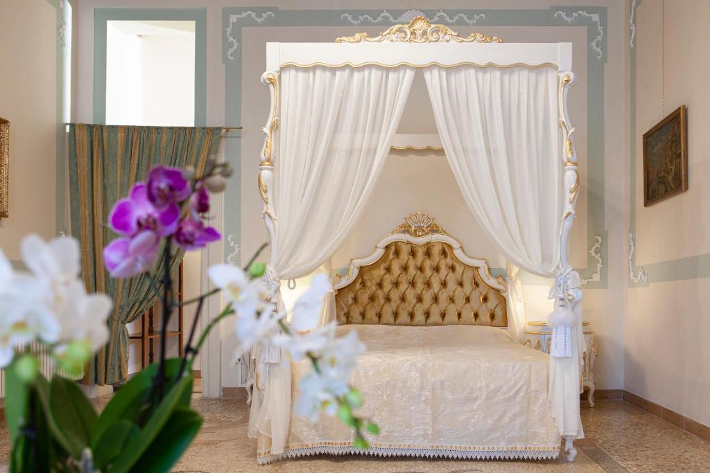 Hotel LUXURY APARTMENT PESARO PAPAFAVA, a bedroom with a white bed with a canopy at LUXURY APARTMENT PESARO PAPAFAVA in Venice