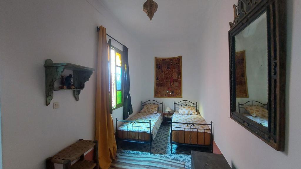 a room with two beds and a mirror at Logement entier riad Dar Sana in Marrakesh