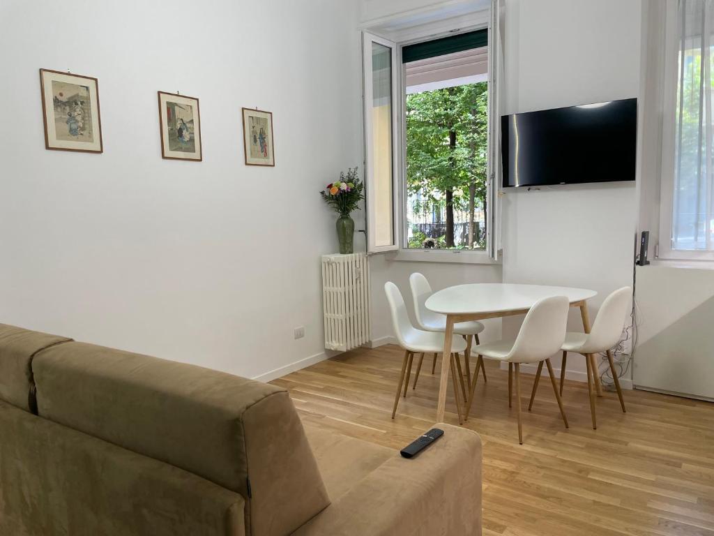 sala de estar con sofá, mesa y sillas en MILA by The Blue Twins apartments Milano en Milán