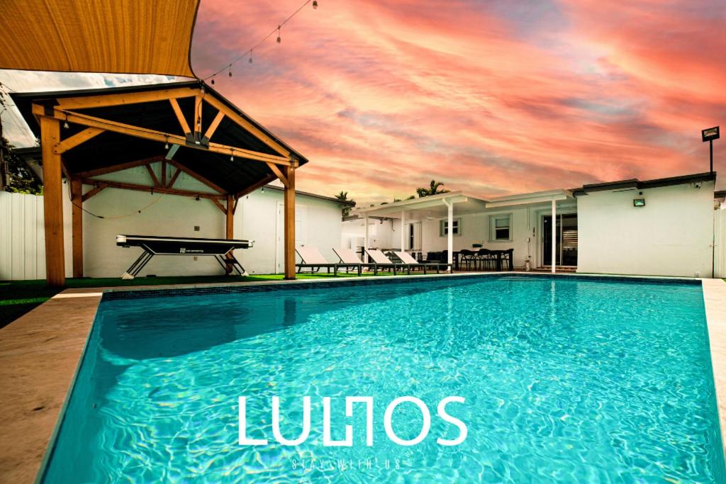 a swimming pool with a sunset in the background at Calle 8 Marvel - Miami Oasis Retreat L55 in Miami
