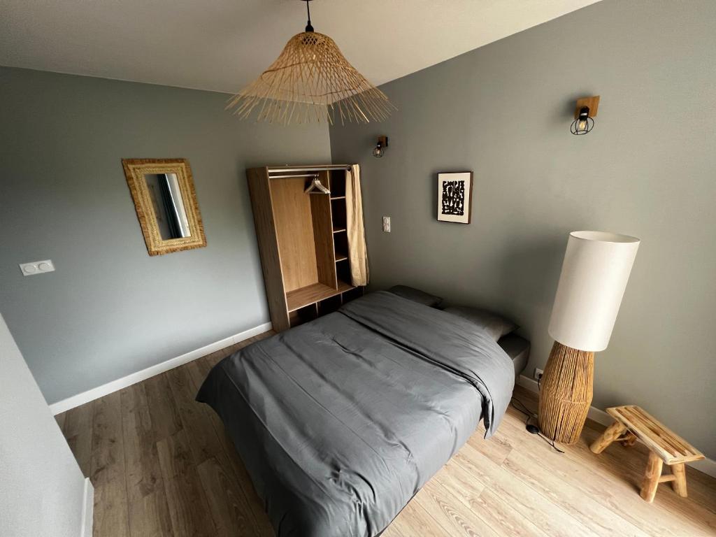 Un dormitorio pequeño con una cama y una lámpara. en Scorfel Lodge, Maison bleue, Terrasse, 1km mer, en Trégastel