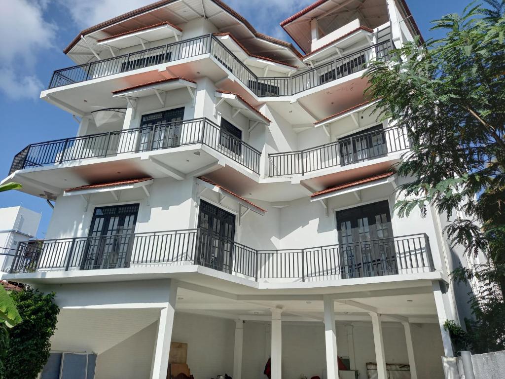 a tall white building with balconies on it at Changami Residence in Nugegoda