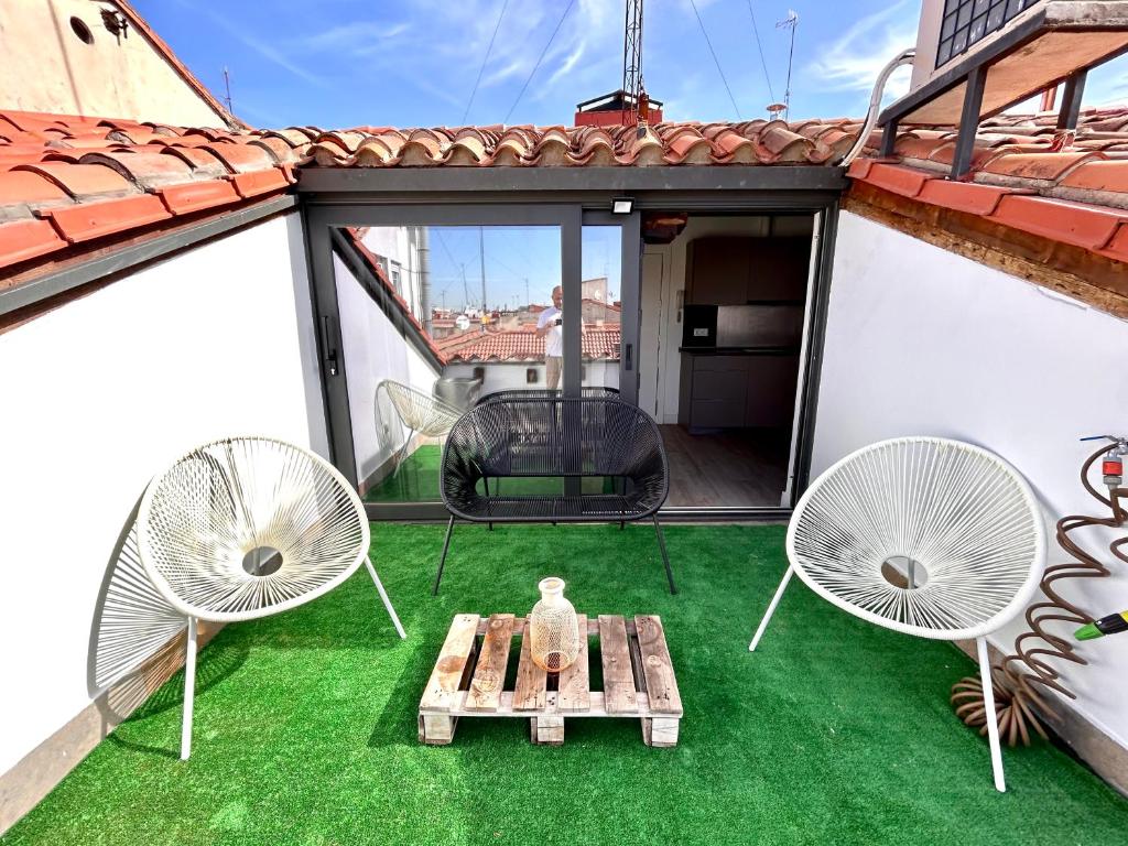 un patio con 2 sillas y una mesa en el techo en Malasaña Sky, en Madrid