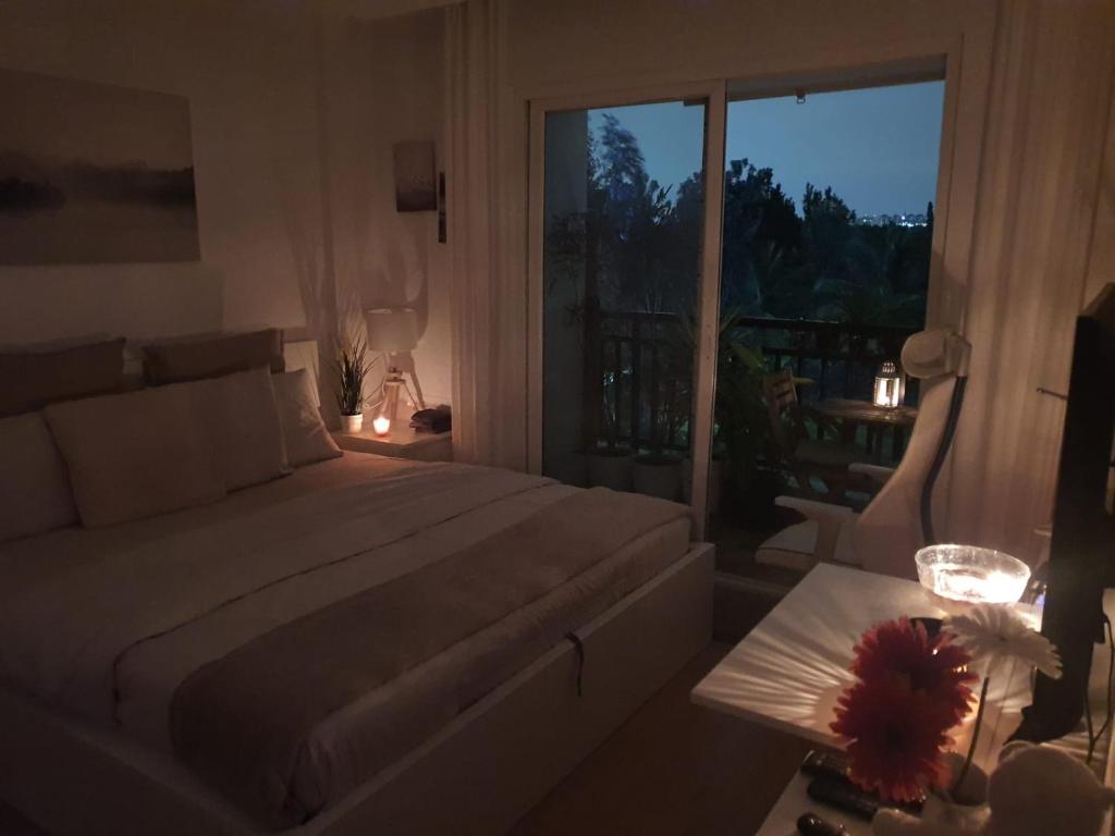 um quarto com uma grande cama branca e uma varanda em Serene Home Stay em Bangalore