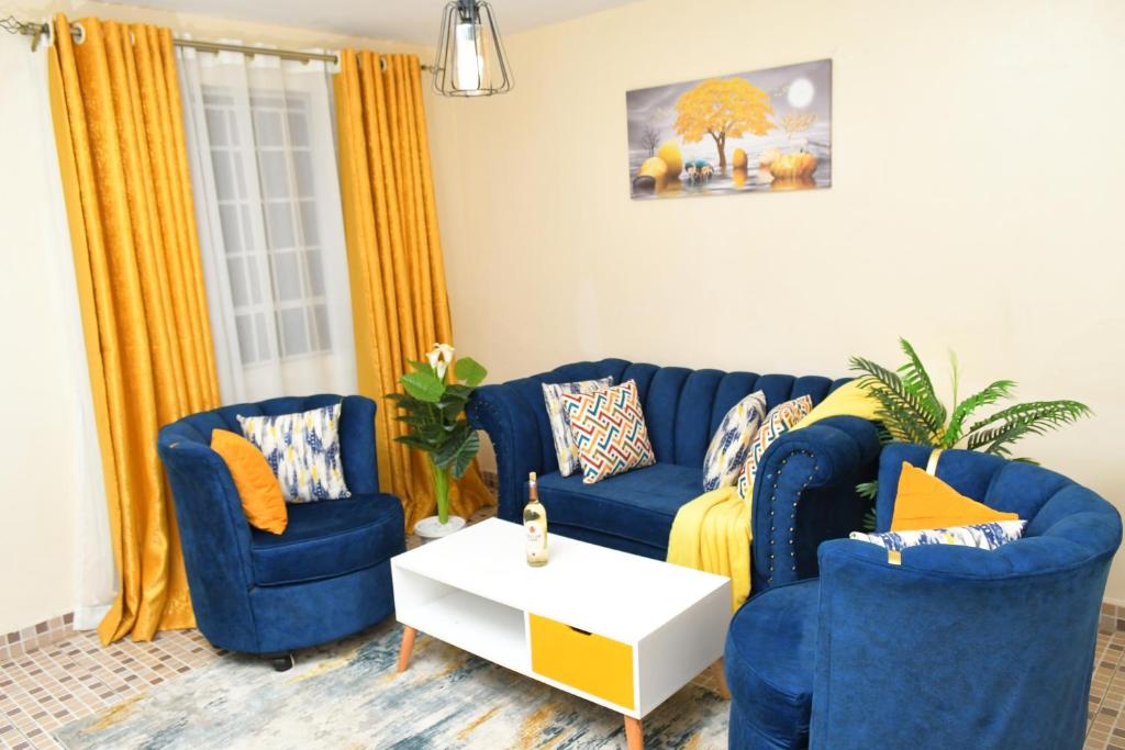 a living room with a blue couch and two chairs at Nomads Luxurious Homes in Nairobi