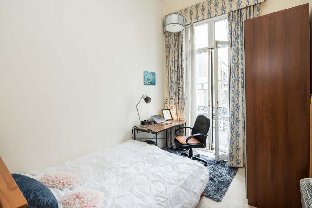 En eller flere senge i et værelse på Cosy High-ceiling Victorian flat with balcony - 2mins to Hyde Park, Kensington Palace, NottingHill, High Street Kensington,2BR 2Baths