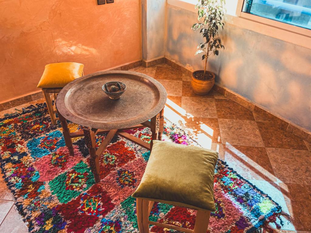 mesa y 2 sillas en una habitación con alfombra en Double Room Private - Sea View en Tamraght Ouzdar
