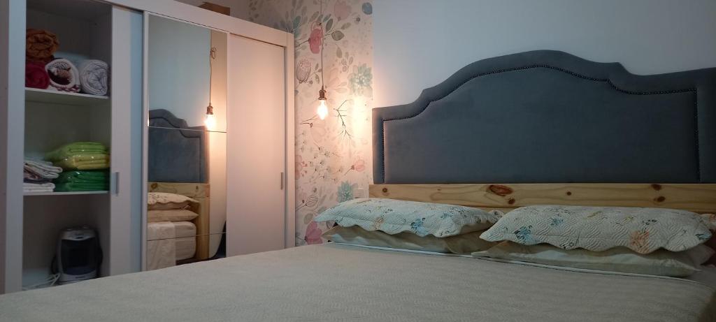 a bedroom with a bed with a headboard and a mirror at Apartamento Le Quartier - no centro, dois quartos, wi-fi, garagem, piscina, ar-condicionado, jacuzzi, sauna, etc in Juiz de Fora