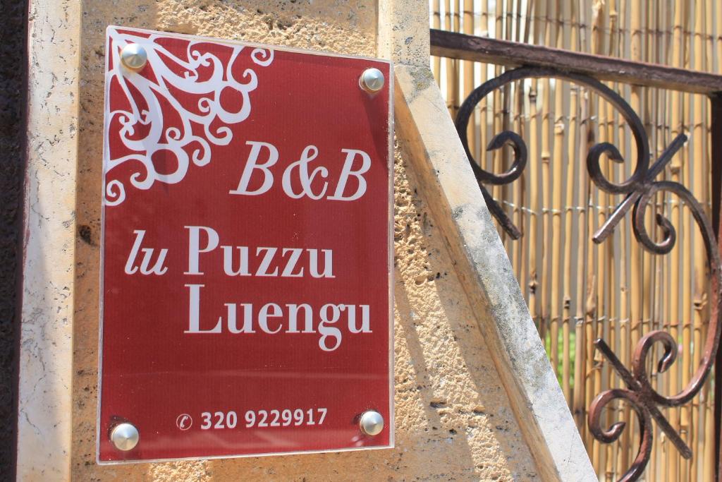 un cartello rosso su un muro accanto a una recinzione di Lu Puzzu Luengu B&B a Leverano